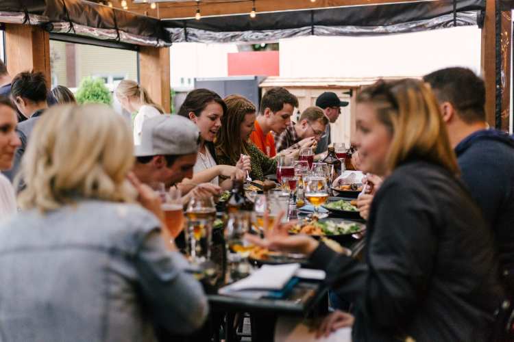 People enjoying food and drinks on a food tour.